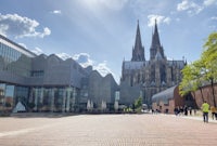 a group of people walking in front of a cathedral
